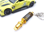 キーホルダー キーリング ショックアブソーバー ダンパー サスペンション 自動車 おしゃれ 記念品 プチギフト プレゼント 贈り物 ファッション小物 女性用 男性用 青 黒 緑 赤 金色 ゴールドカラー